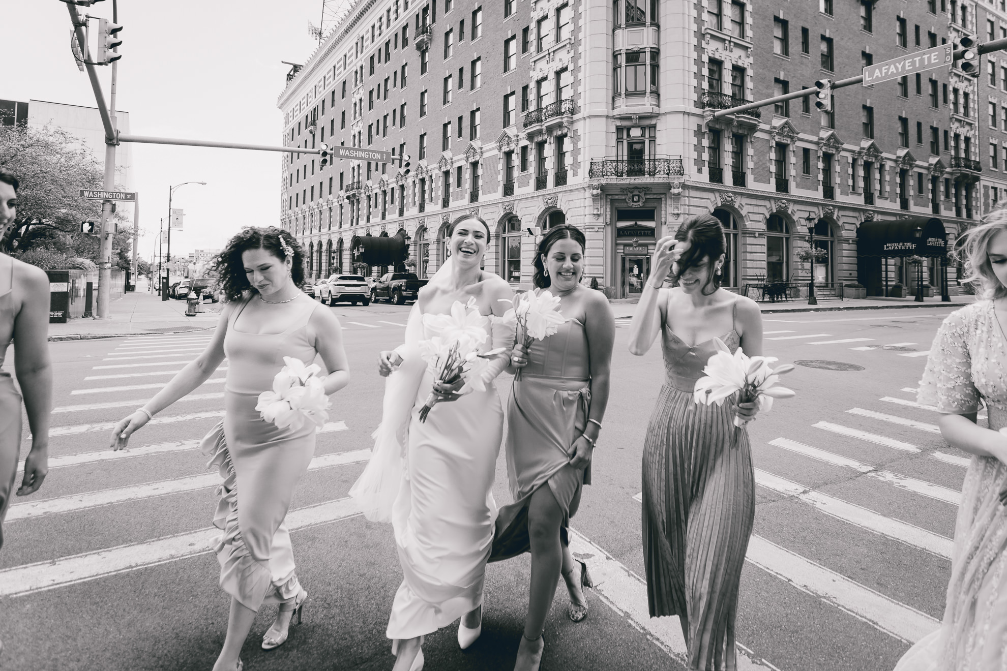 bridesmaids cross street in downtown Buffalo before wedding