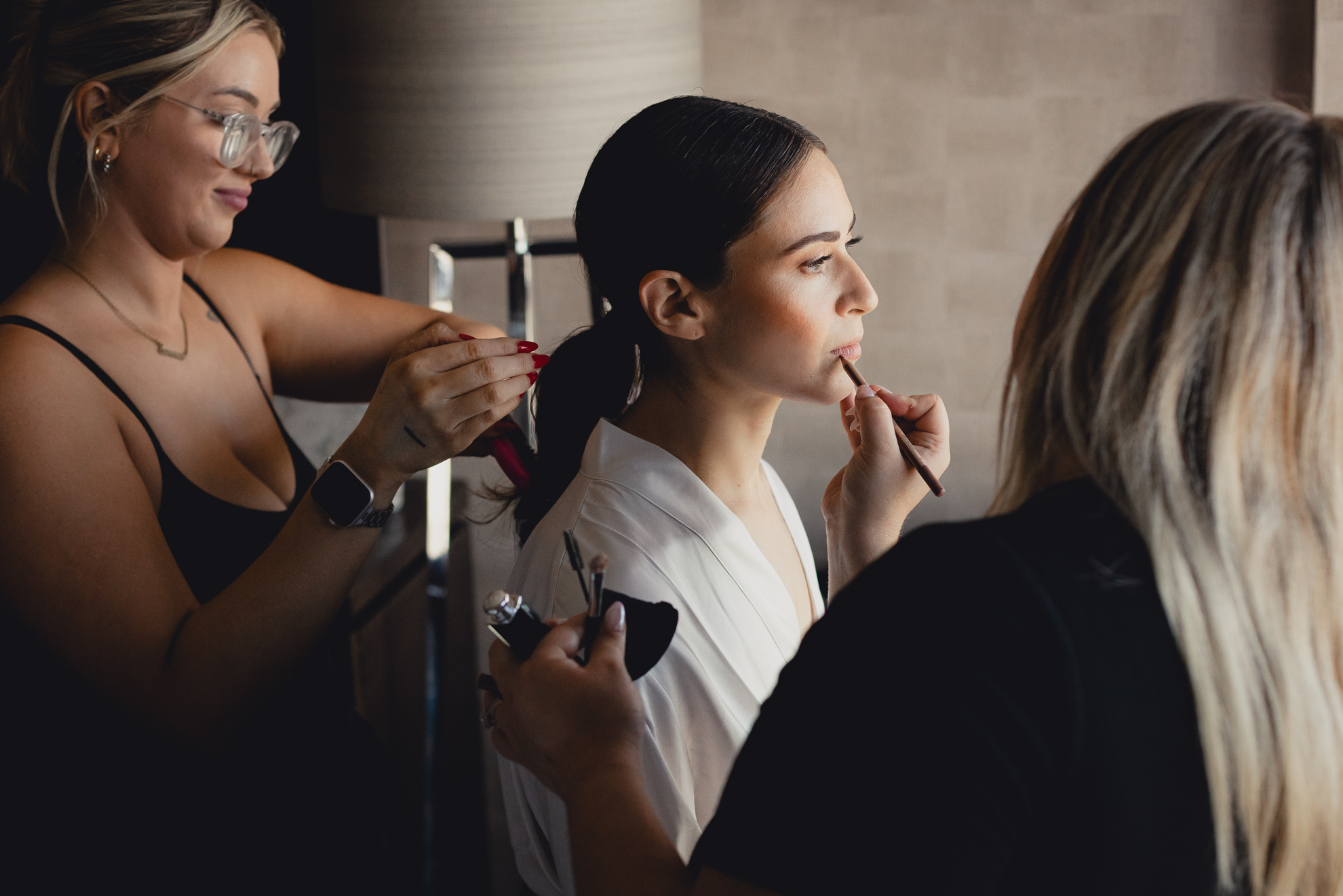 bride has makeup applied and hair touched up before wedding at Marriott Lecom Harborcenter