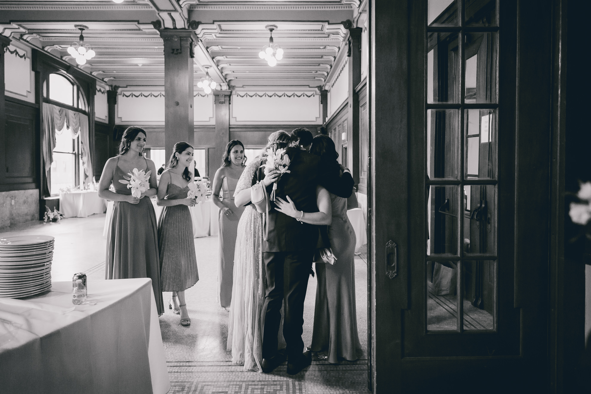 groom hugs bridesmaids before wedding ceremony in the Golden Ballroom of the Hotel Lafayette