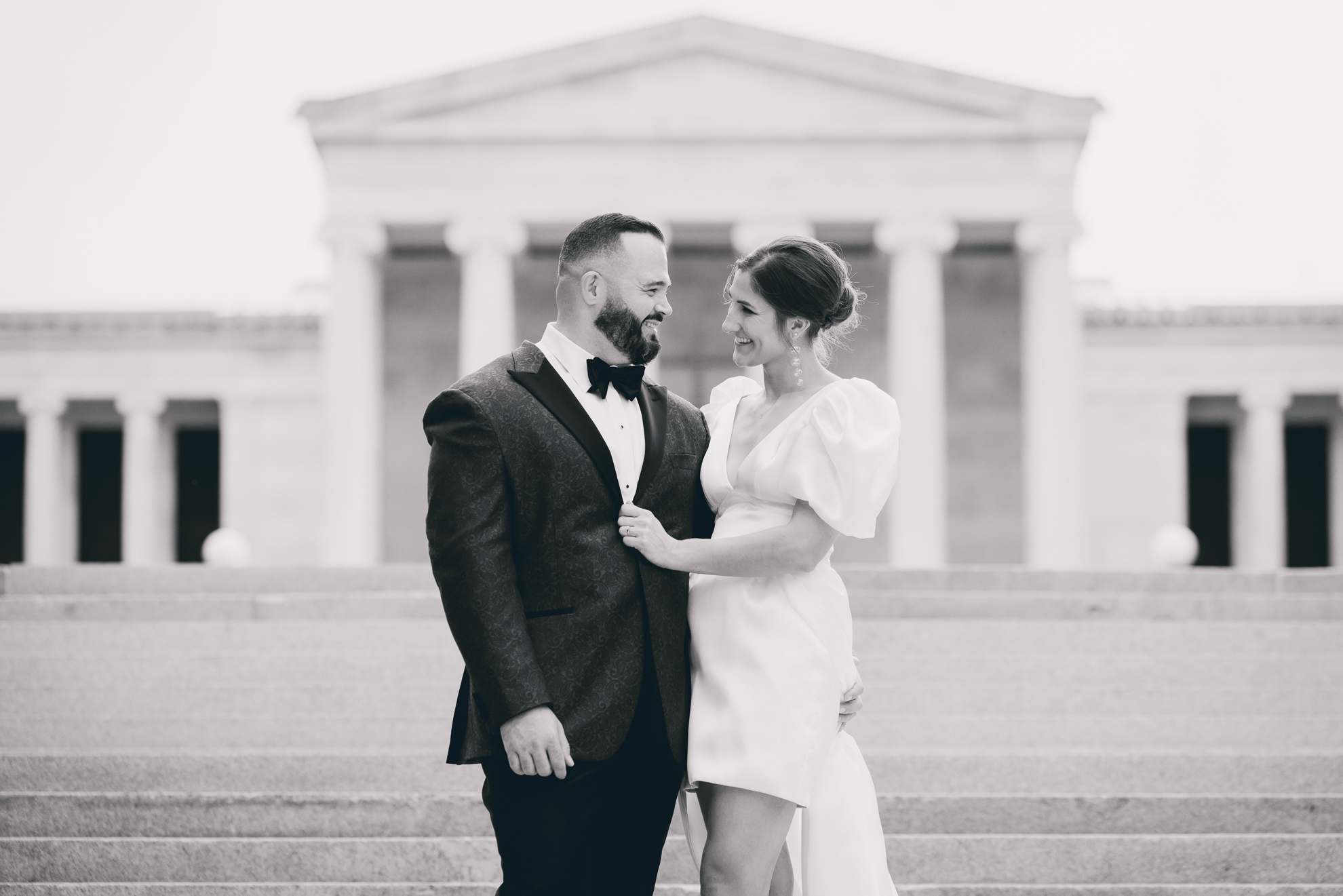 bride and groom pose for wedding portraits in front of AKG in Buffalo, NY