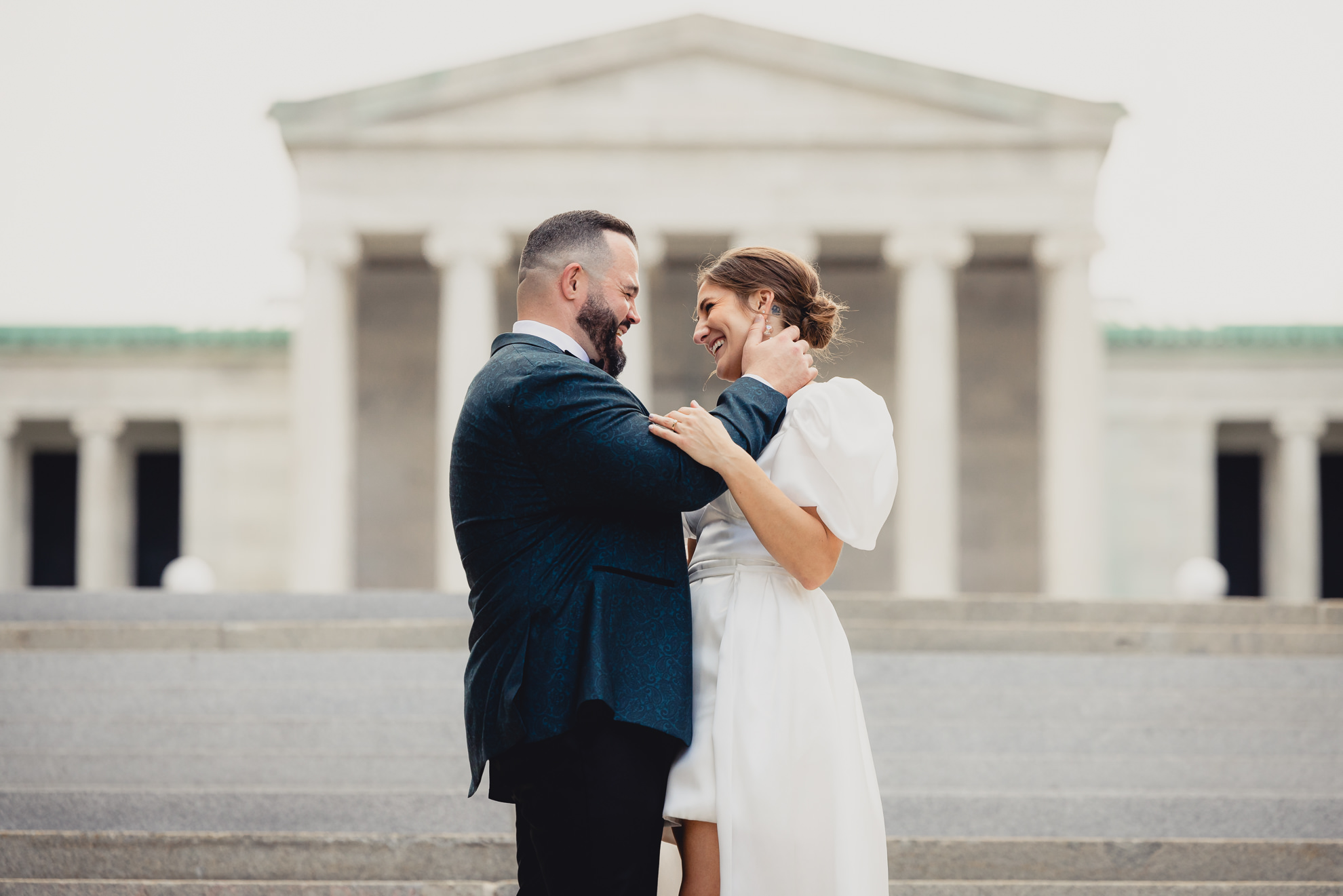 bride and groom pose for wedding portraits in front of AKG in Buffalo, NY