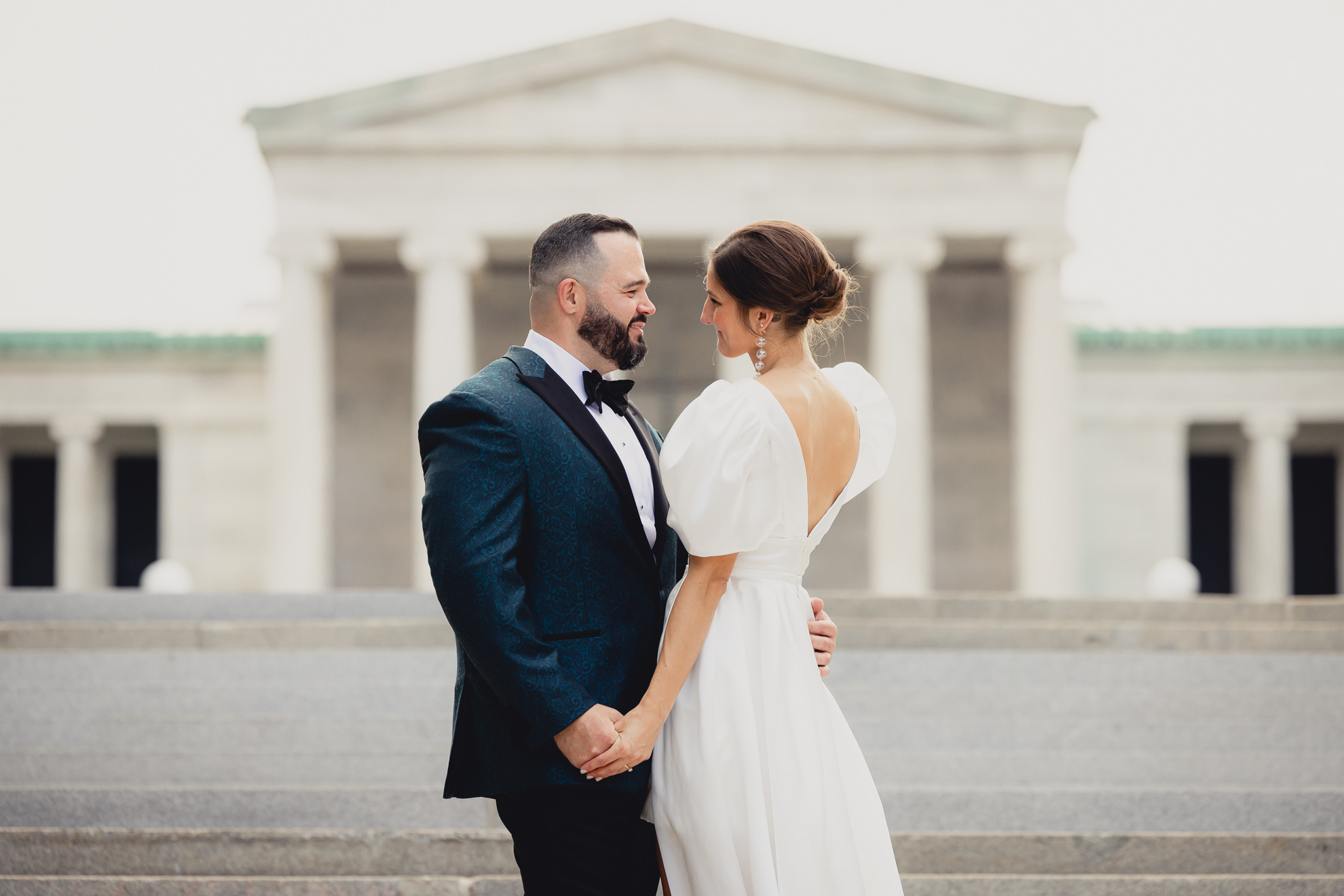 bride and groom pose for wedding portraits in front of AKG in Buffalo, NY