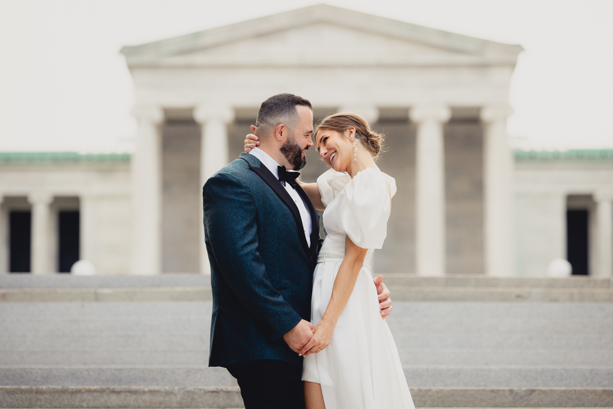 bride and groom pose for wedding portraits in front of AKG in Buffalo, NY