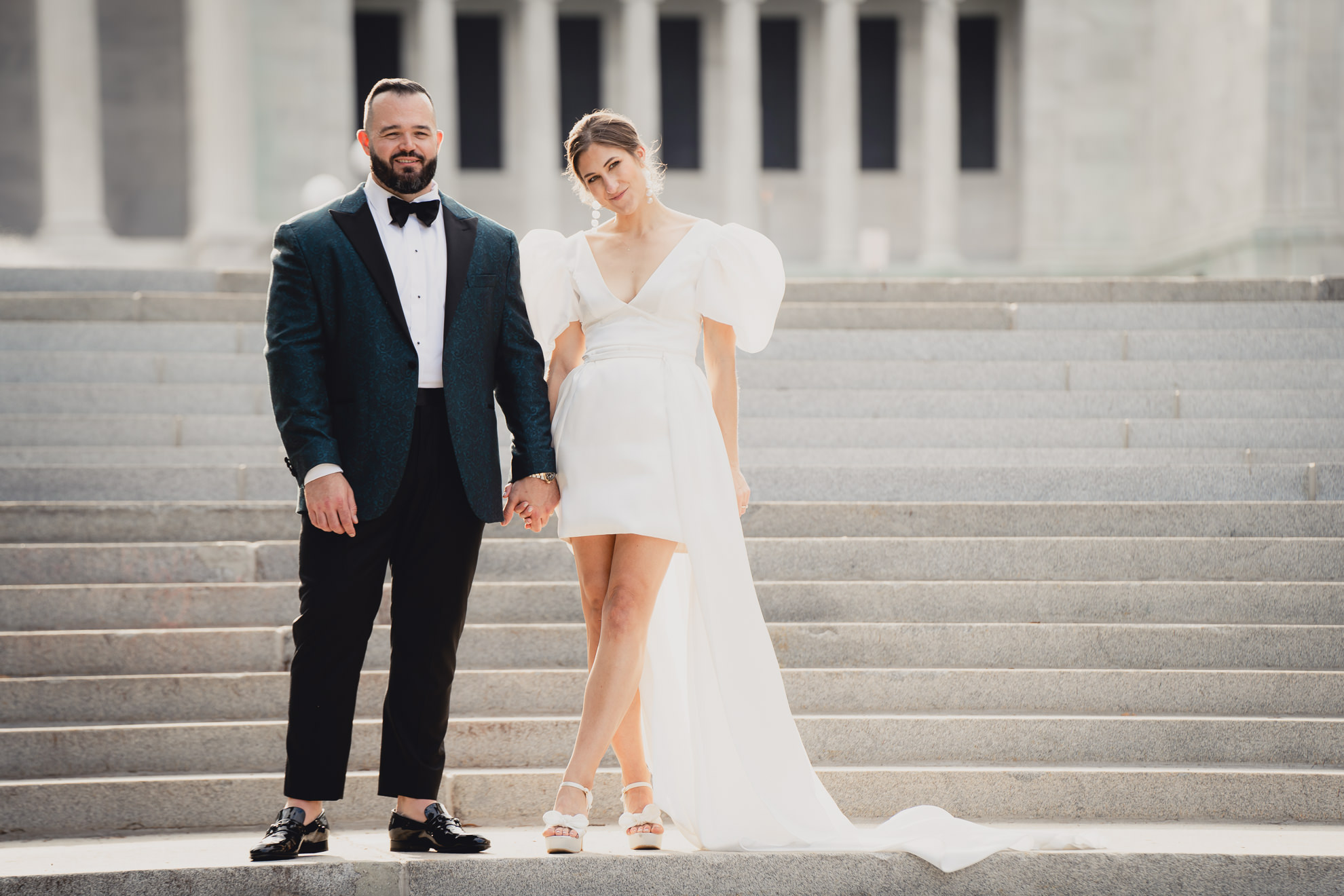 bride and groom pose for wedding portraits in front of AKG in Buffalo, NY