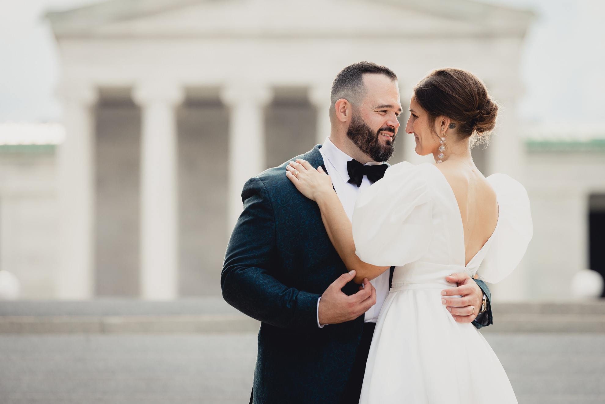 bride and groom pose for wedding portraits in front of AKG in Buffalo, NY