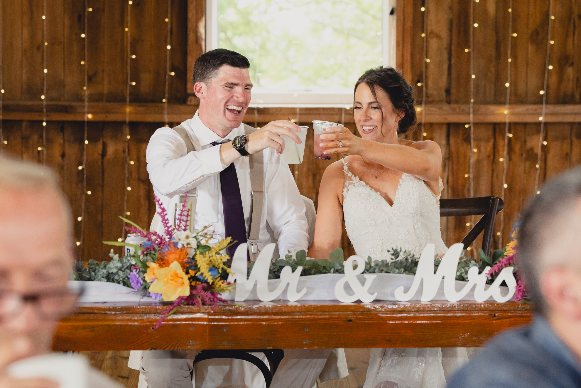bride and groom cheers during wedding reception at The Gallagher Barn in Medina, NY