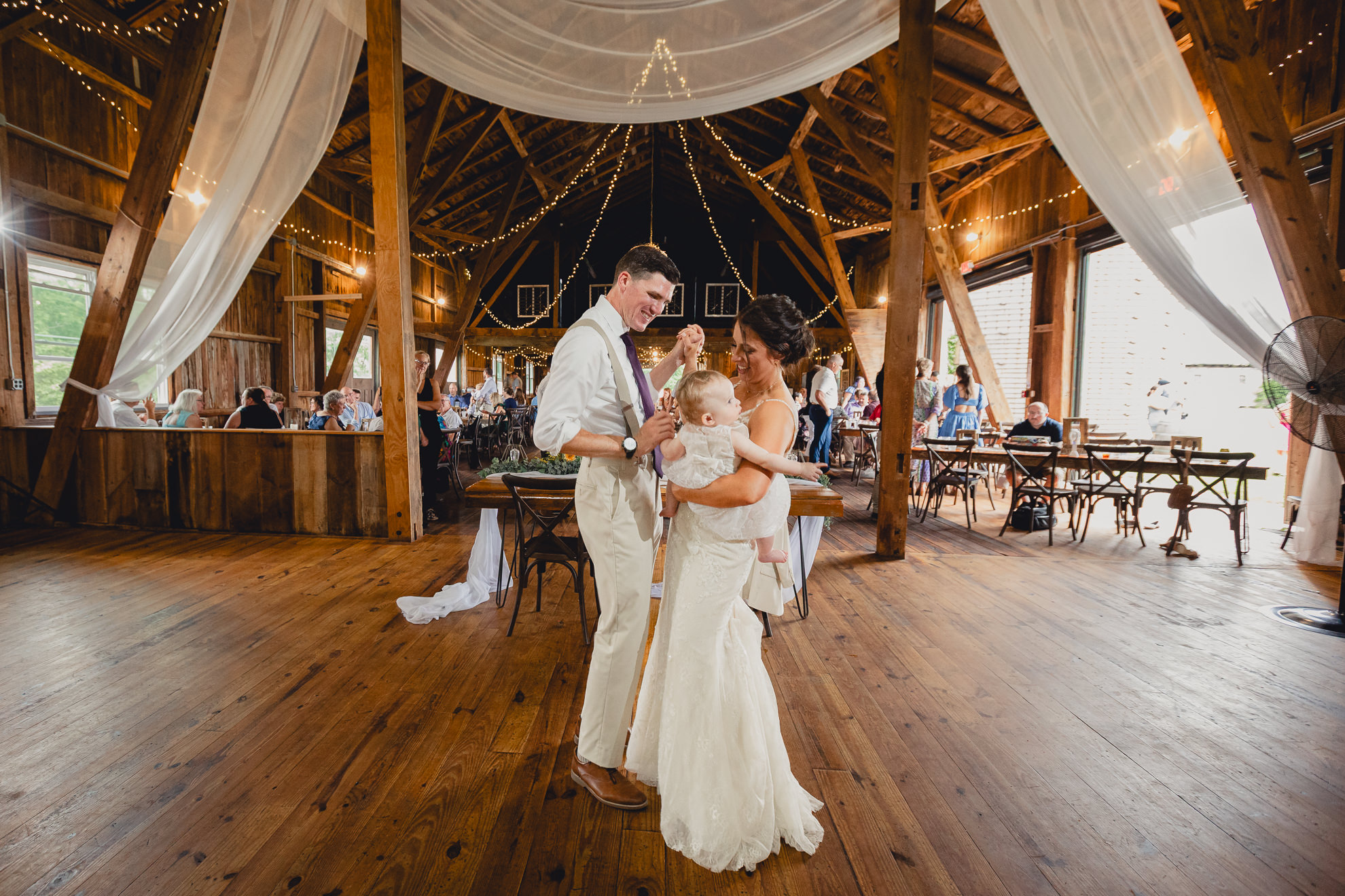 bride groom and baby dance during wedding reception at The Gallagher Barn in Medina, NY