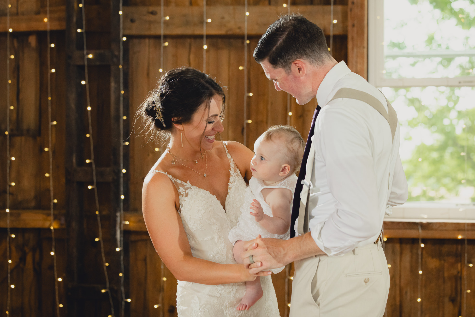 bride groom and baby dance during wedding reception at The Gallagher Barn in Medina, NY