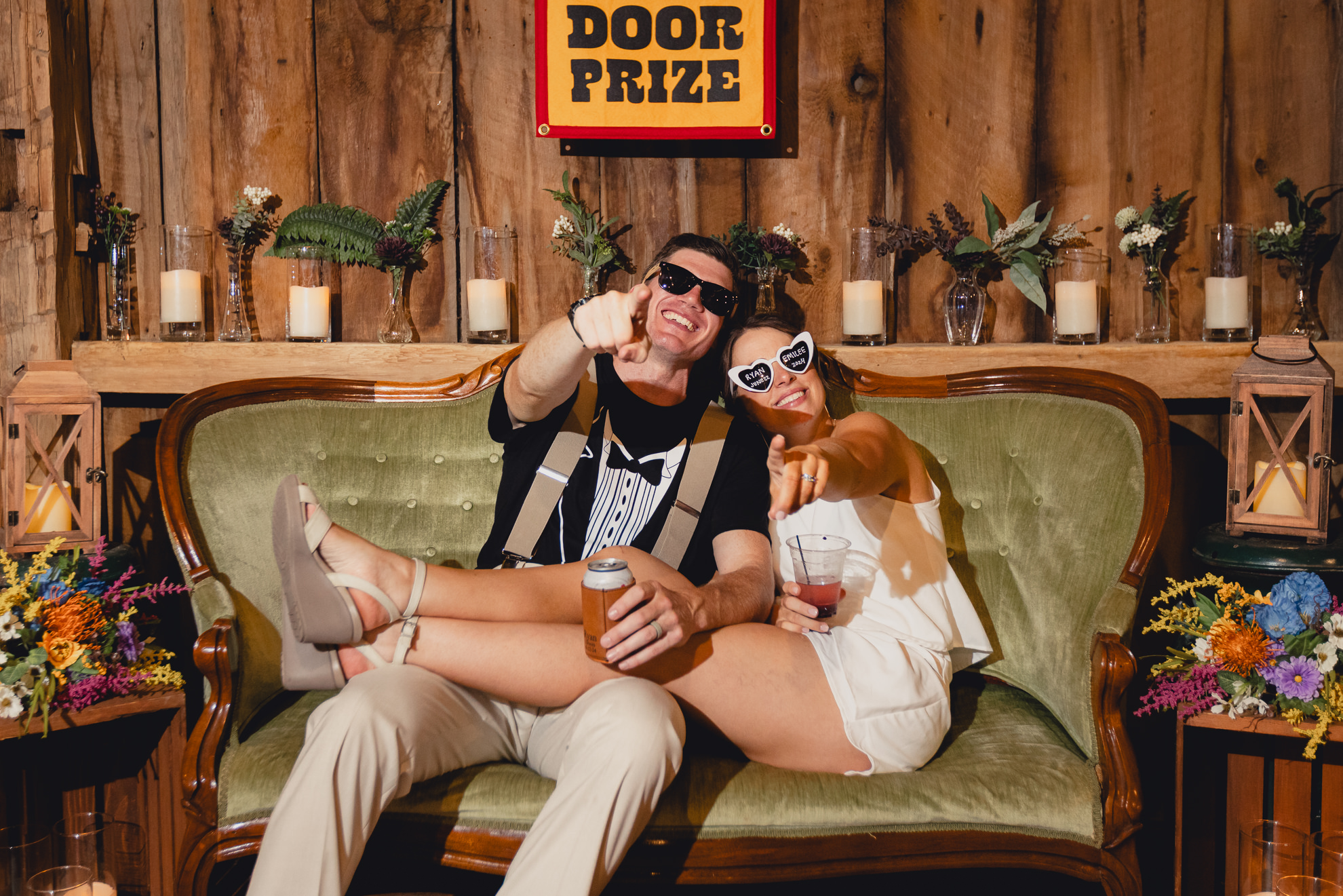 bride and groom pose for wedding photography portrait on couch during wedding reception at The Gallagher Barn in Medina, NY