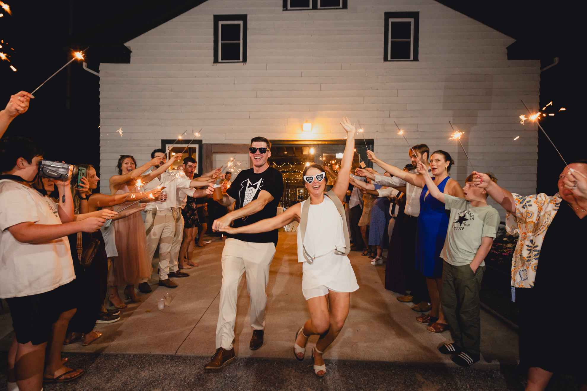 bride and groom walk through sparkler exit after wedding reception at The Gallagher Barn in Medina, NY