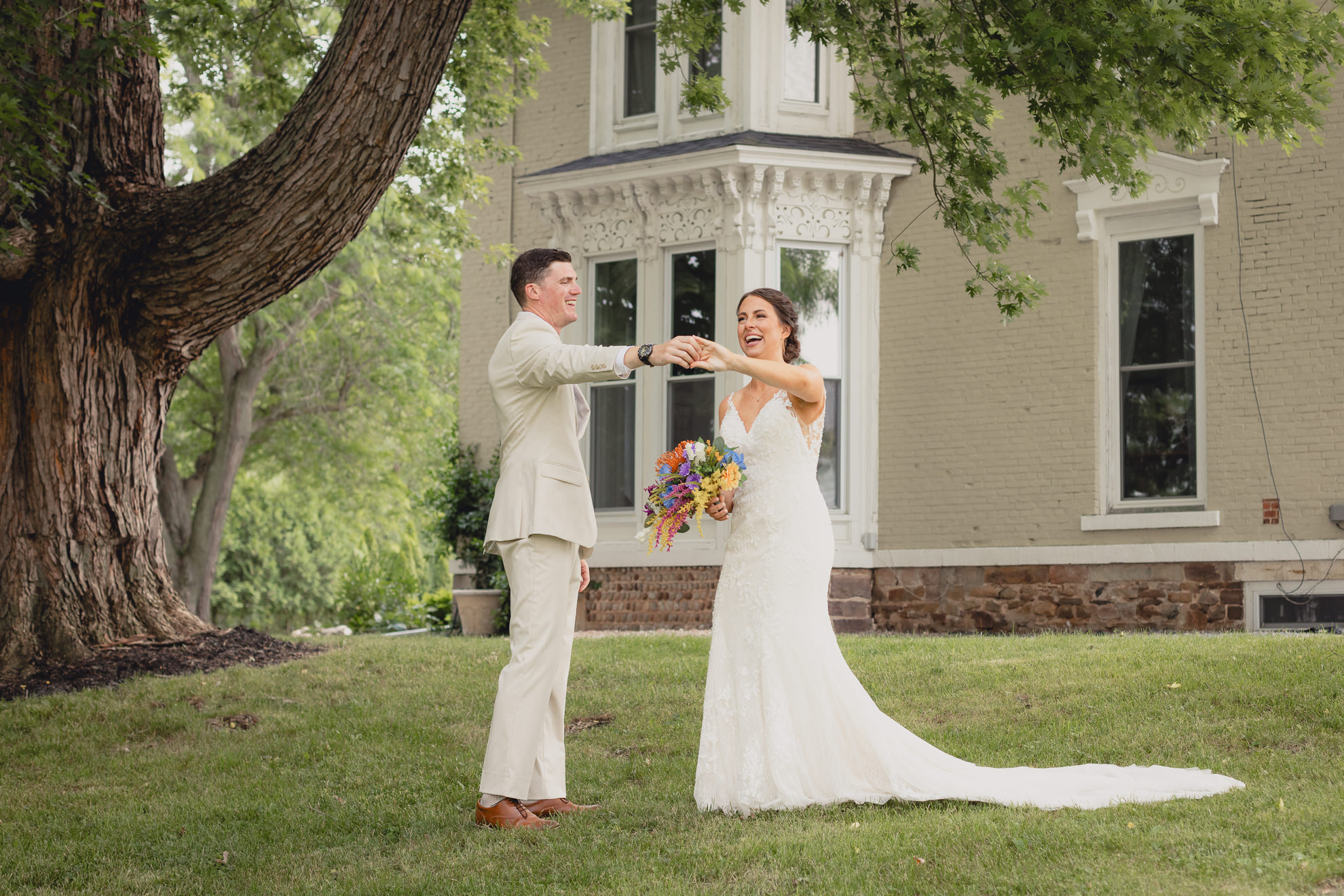 groom spins bride outside historic house at The Gallagher Barn in Medina, NY
