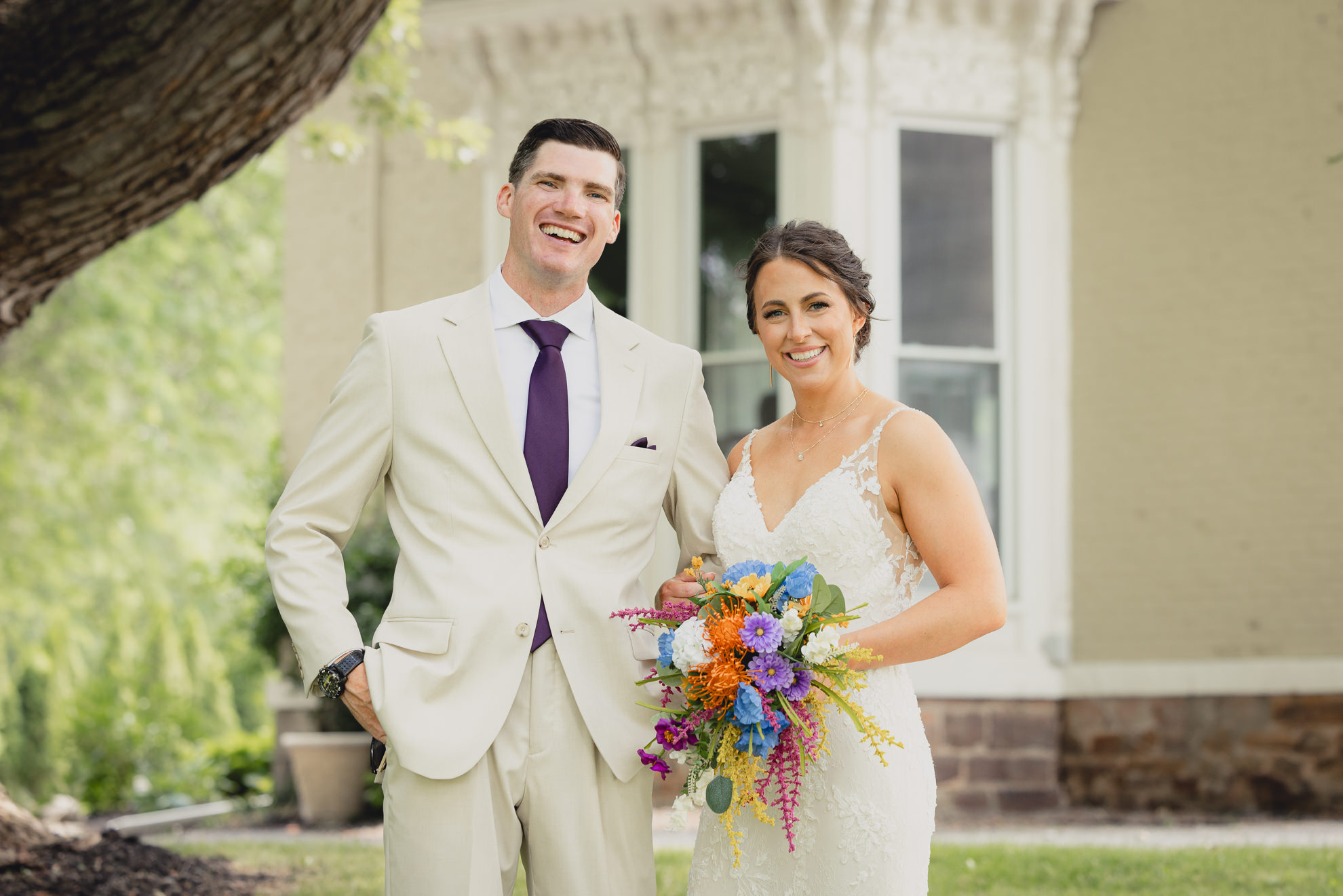 bride and groom pose for wedding photography portrait outside historic house at The Gallagher Barn in Medina, NY