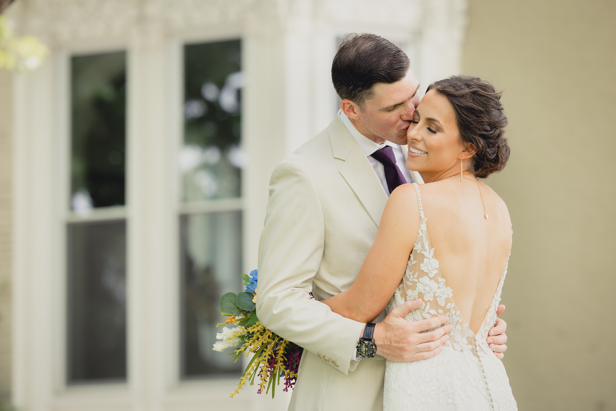 bride and groom pose for wedding photography portrait outside historic house at The Gallagher Barn in Medina, NY