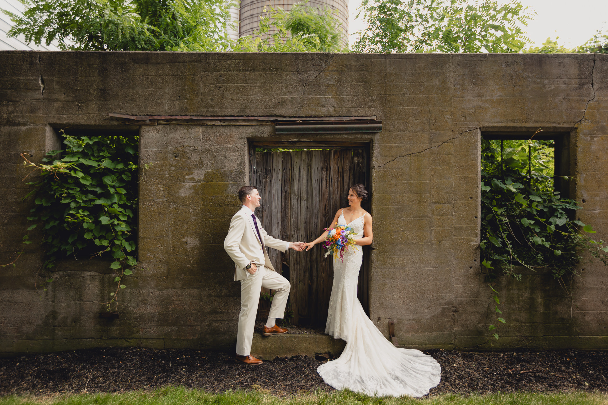 bride and groom pose for wedding photography portrait outside The Gallagher Barn in Medina, NY