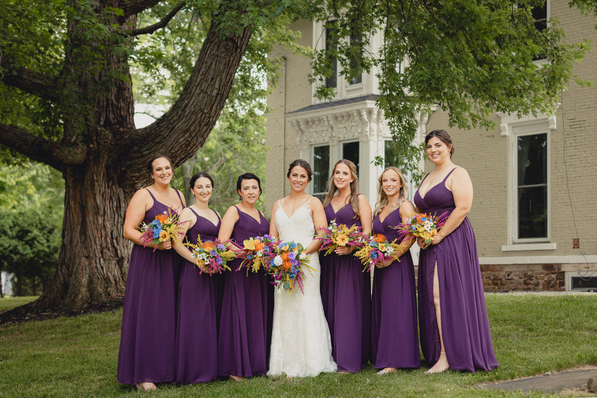 bridesmaids pose for portrait outside historic house at The Gallagher Barn in Medina, NY