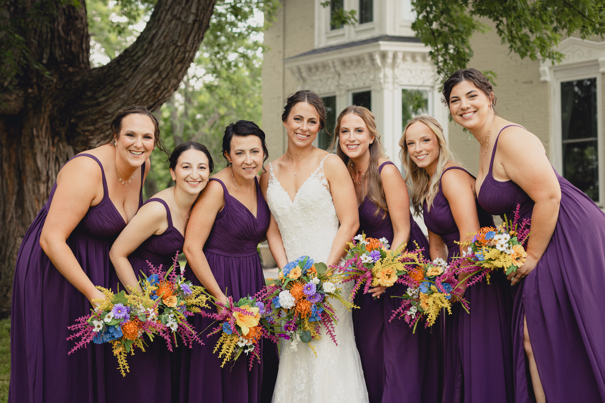 bridesmaids pose for portrait outside historic house at The Gallagher Barn in Medina, NY