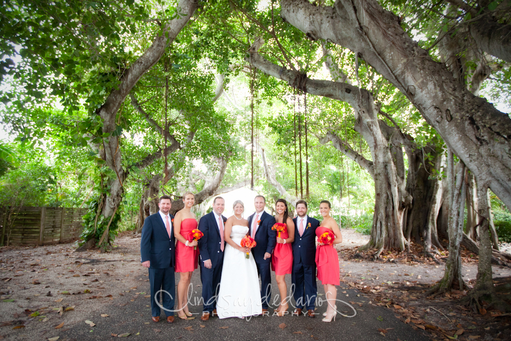 wedding party poses for photographer under banyan trees after destination wedding ceremony on Gasparilla Island Boca Grande, FL