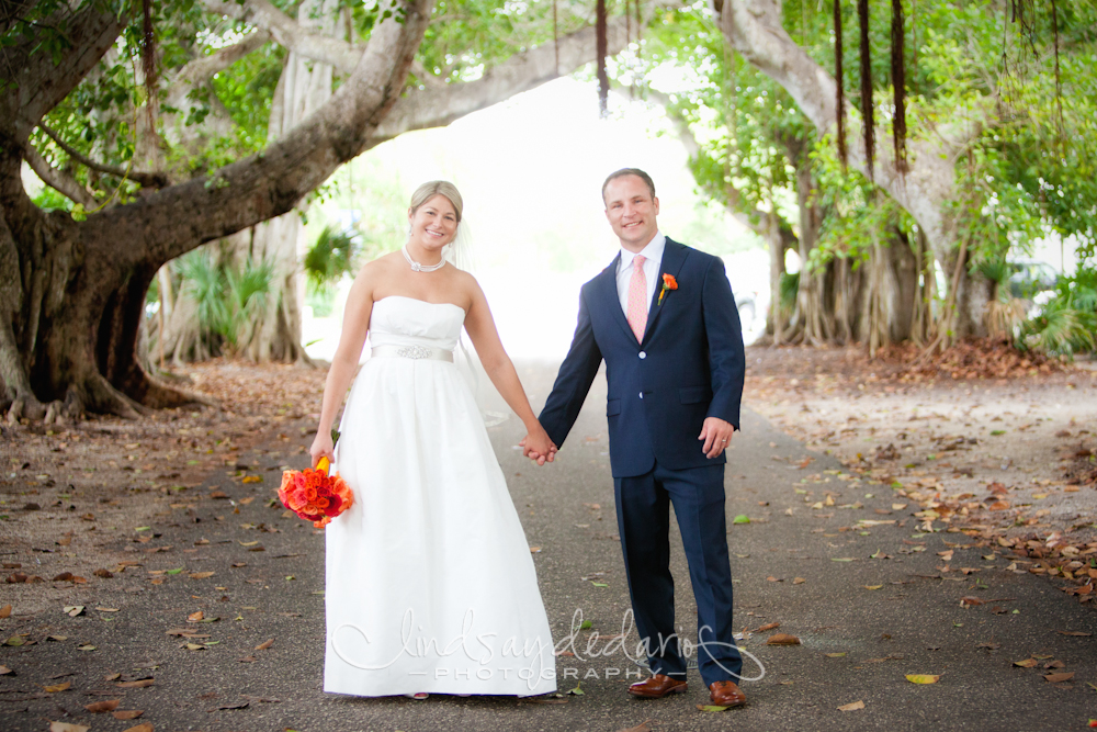 bride and groom hold hands under banyan trees after destination wedding ceremony on Gasparilla Island Boca Grande, FL