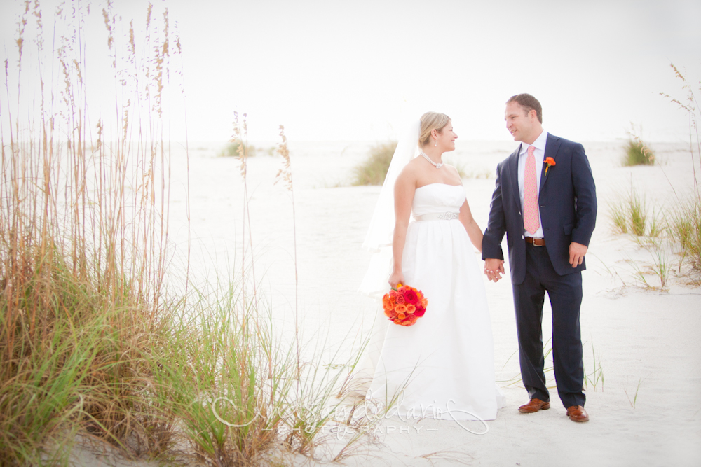 bride and groom hold hands and smile on beach after destination wedding ceremony on Gasparilla Island Boca Grande, FL