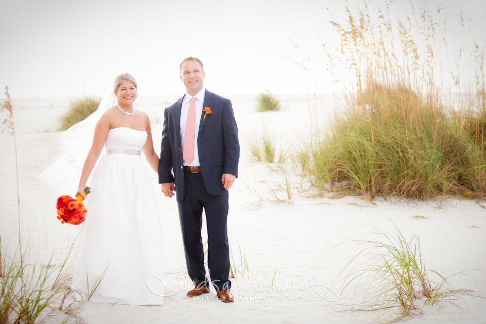 bride and groom smile for photographer on beach after destination wedding ceremony on Gasparilla Island Boca Grande, FL