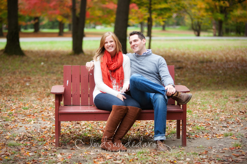 couple laughs on bench in Chestnut Ridge Park during their engagement portrait photo in Orchard Park, NY