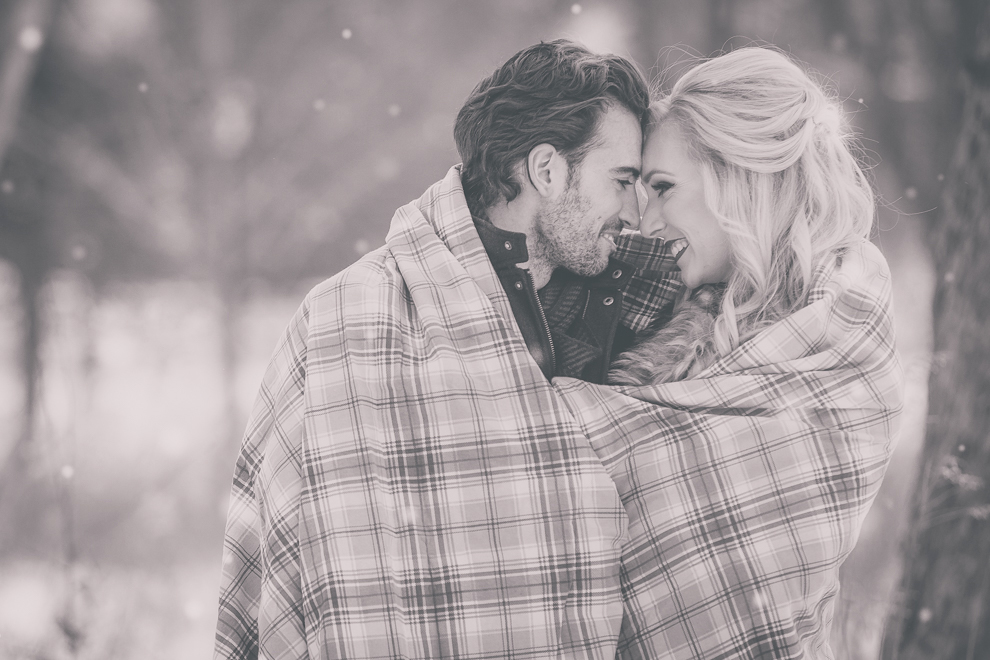 wedding engagement photography of couple wrapped in blanket at Delaware Park in Buffalo, NY
