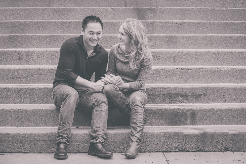 Two Niagara University Alumni laugh on steps during their wedding engagement photography session