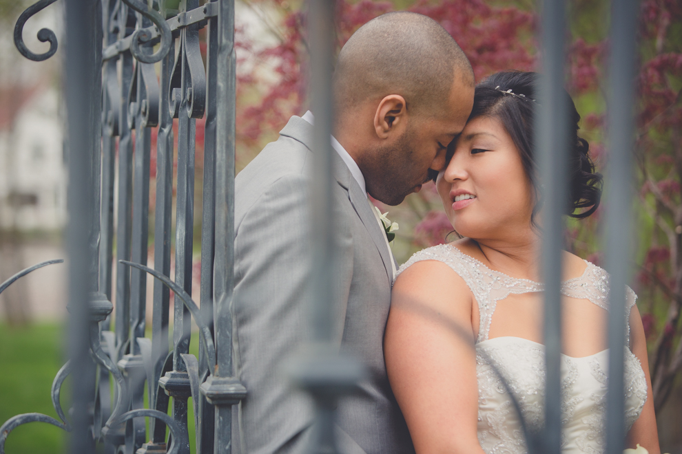 bride and groom look at each other in garden at outdoor wedding ceremony venue, the Avanti Mansion, near Buffalo, NY