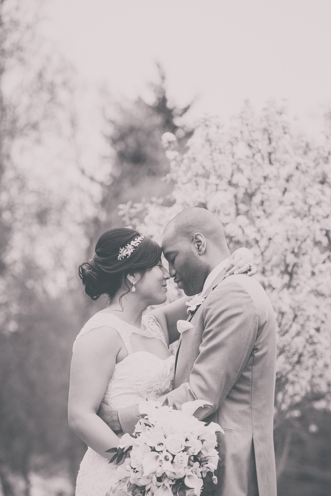 bride and groom touch noses in garden at outdoor wedding ceremony venue, the Avanti Mansion, near Buffalo, NY