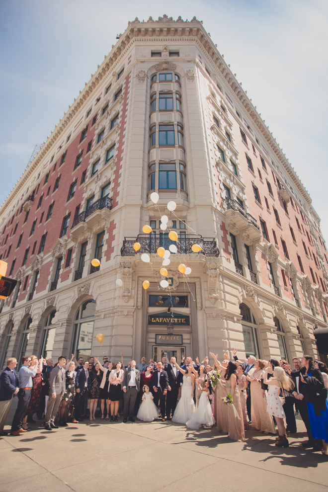 guests and bridal party release balloons at whimsical urban woodland themed wedding in buffalo, ny at webb lofts, lafayette hotel, pearl st brewery in Buffalo, NY