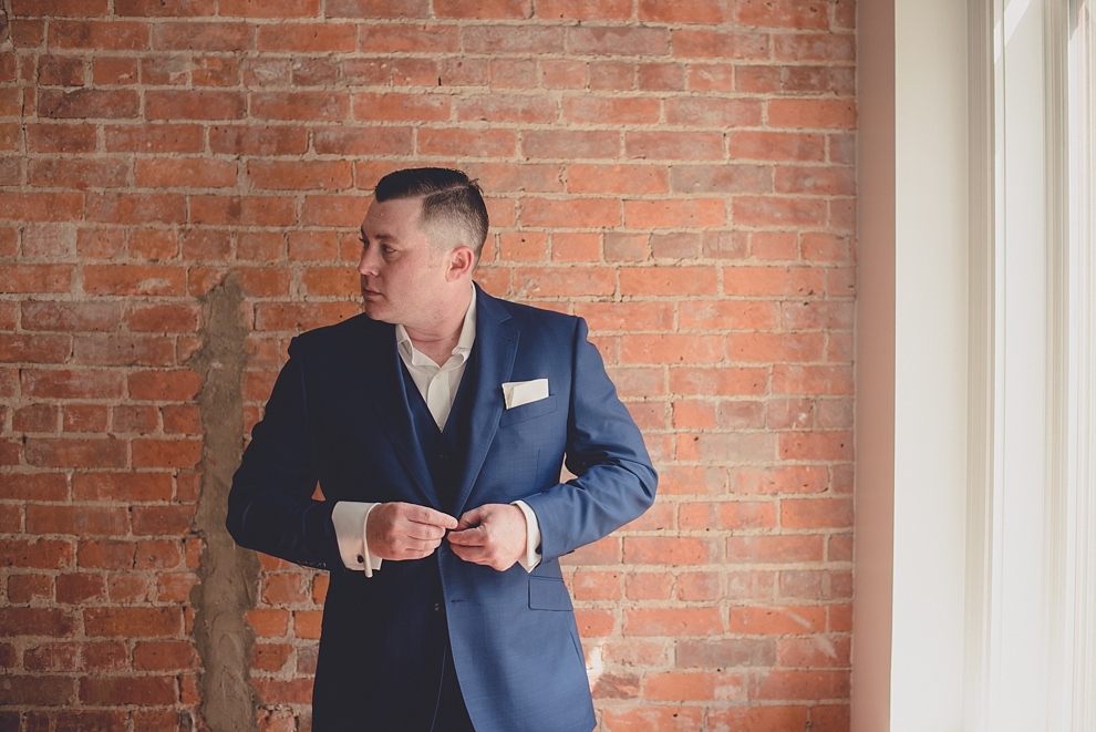 groom prepares for wedding in hotel room at Webb Lofts on Pearl St. in Buffalo, NY