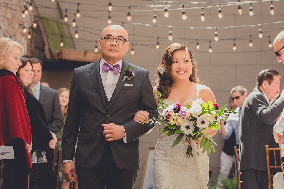 bride and groom cheer after father walks bride down the aisle at whimsical urban woodland themed wedding ceremony at webb lofts, lafayette hotel, pearl st brewery in Buffalo, NY