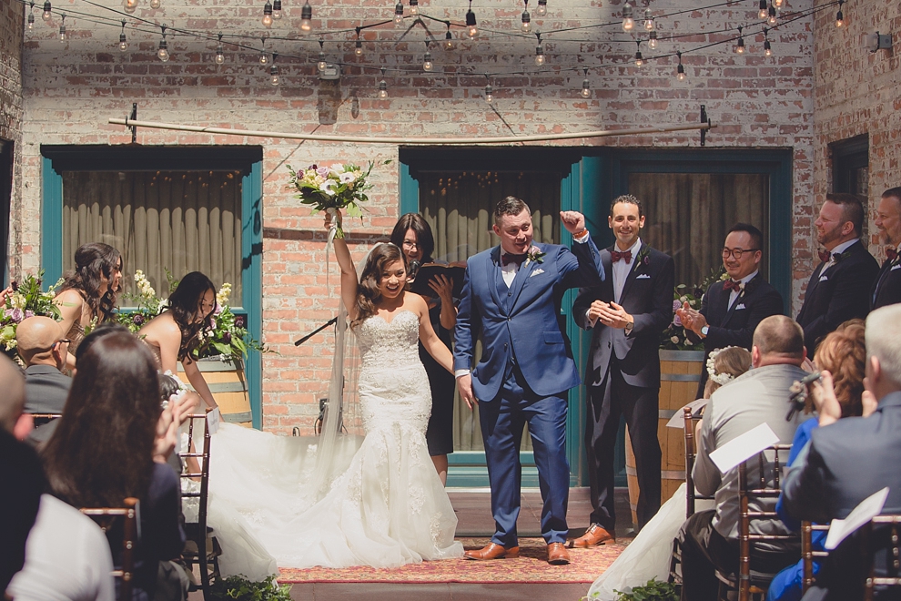 bride and groom cheer after whimsical urban woodland themed wedding ceremony at webb lofts, lafayette hotel, pearl st brewery in Buffalo, NY