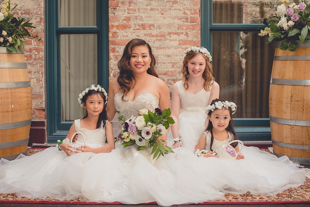 bride sits with flower girls after whimsical urban woodland themed wedding ceremony at webb lofts, lafayette hotel, pearl st brewery in Buffalo, NY