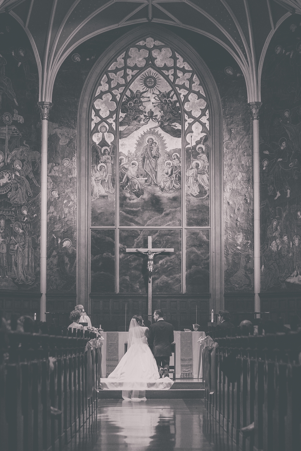 bride and groom kneel during wedding at St. Joseph's University Parish Church in Buffalo, NY