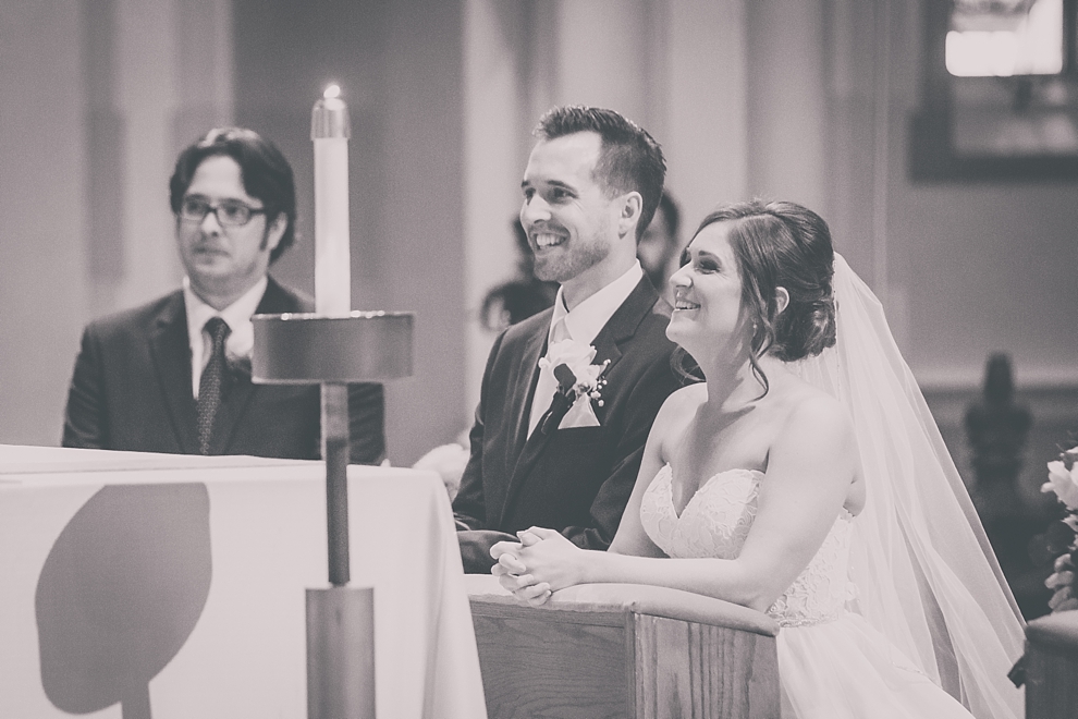 bride and groom smile during wedding at St. Joseph's University Parish Church in Buffalo, NY