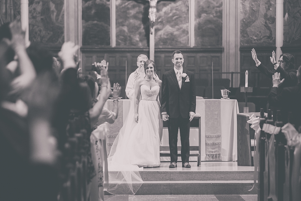 guests pray for bride and groom during wedding at St. Joseph's University Parish Church in Buffalo, NY