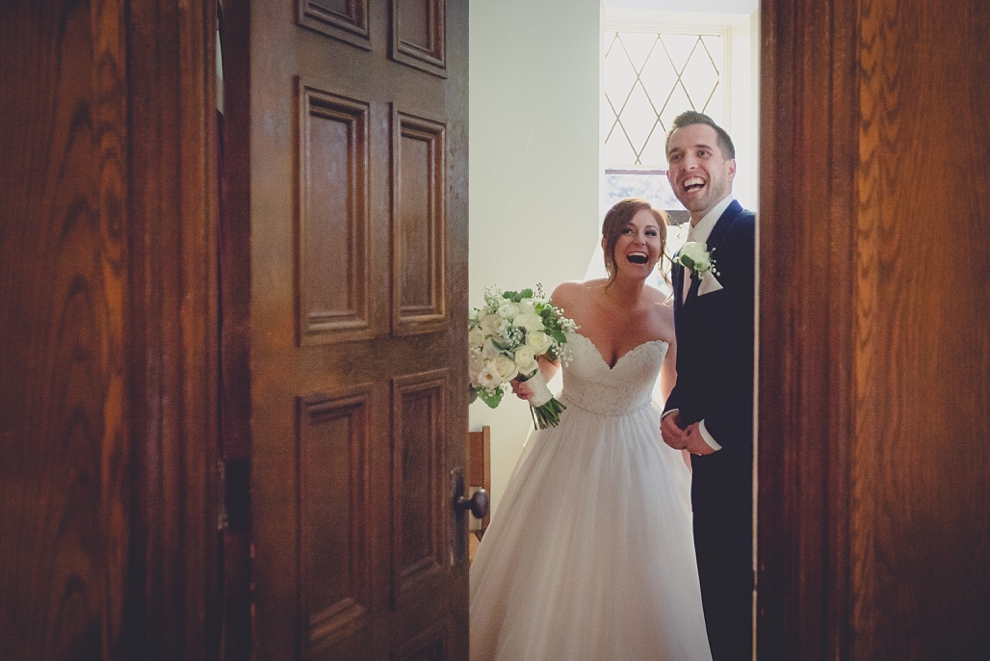 bride and groom look out door during wedding at St. Joseph's University Parish Church in Buffalo, NY