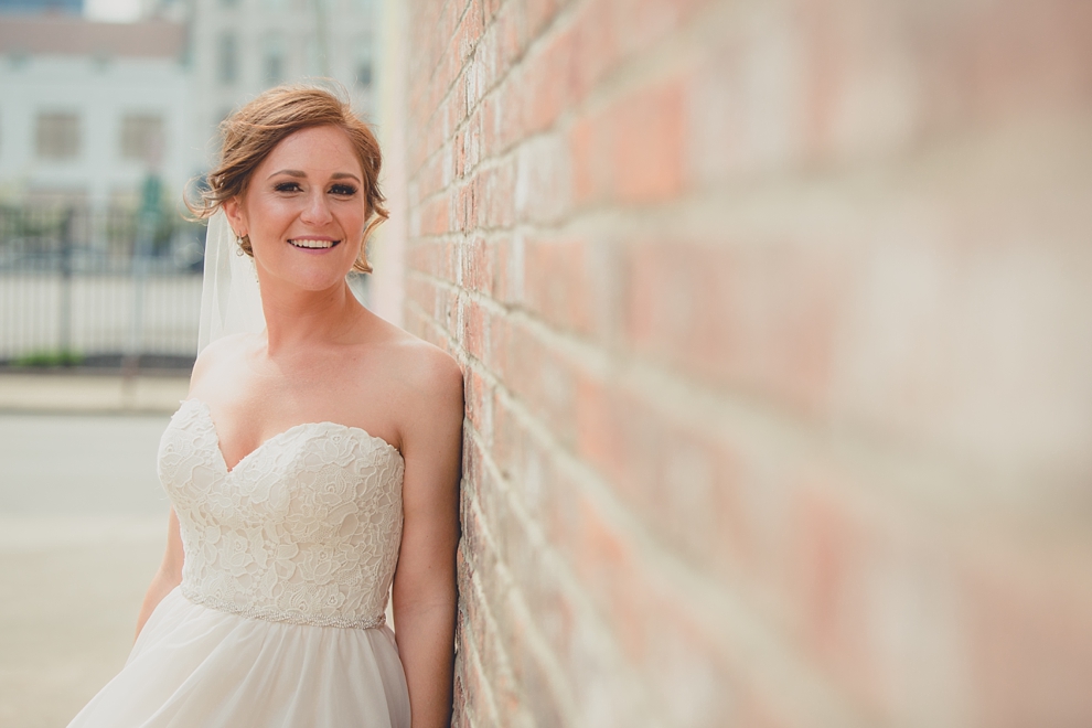 bride poses for portrait near "greetings from Buffalo" mural in downtown Buffalo, NY