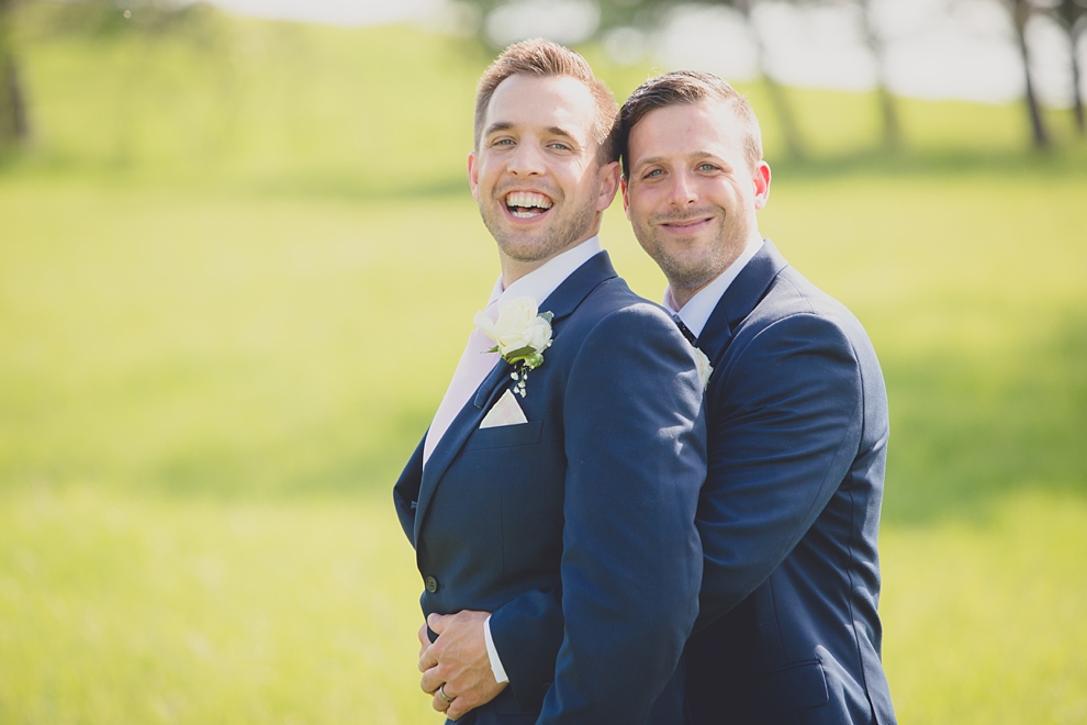 groomsmen hug at Tifft Nature preserve during wedding in Buffalo, NY