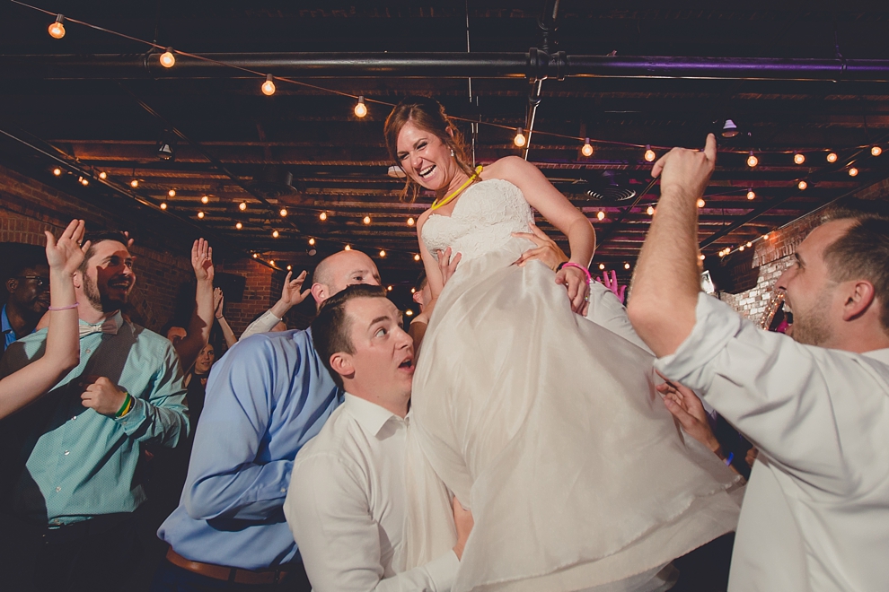 guests lift bride during horah at wedding at Pearl Street Grill and Brewery in Buffalo, NY