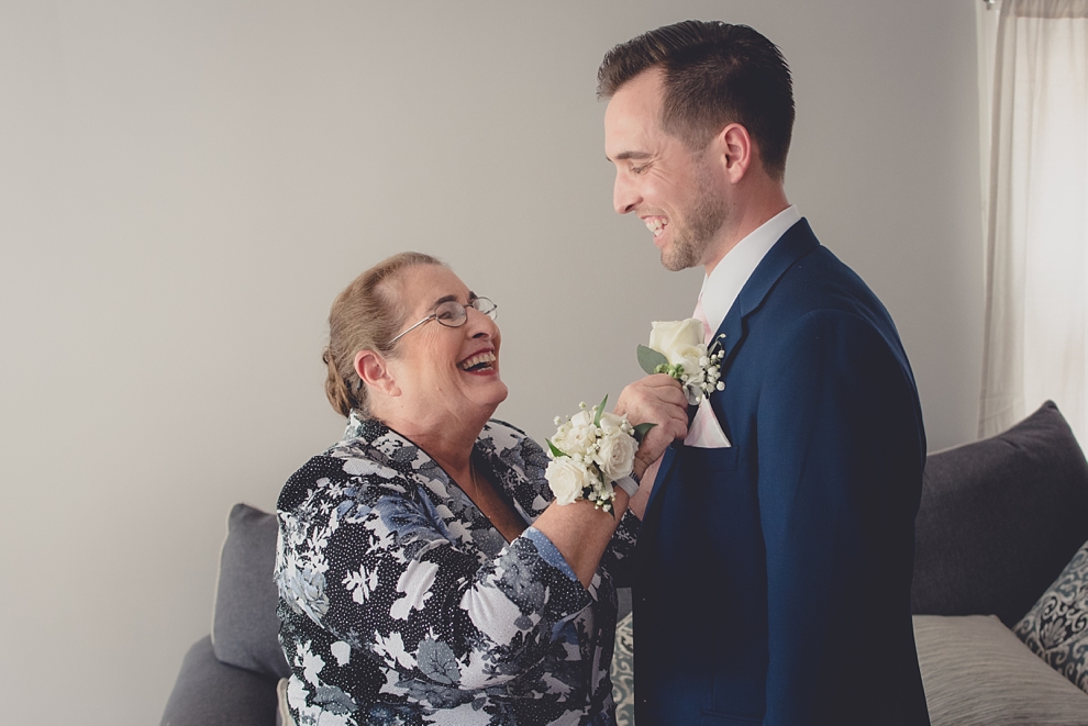 mother of groom pins flower at wedding in buffalo ny
