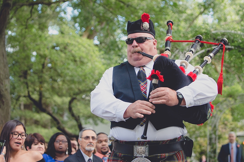 bagpipe player walks down aisle before garden wedding ceremony at Samuel's Grande Manor near Buffalo, NY