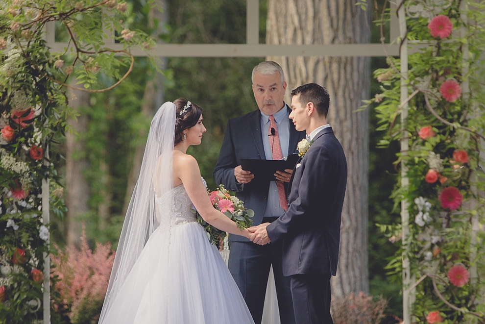 bride and groom exchange vowsduring garden wedding ceremony at Samuel's Grande Manor near Buffalo, NY