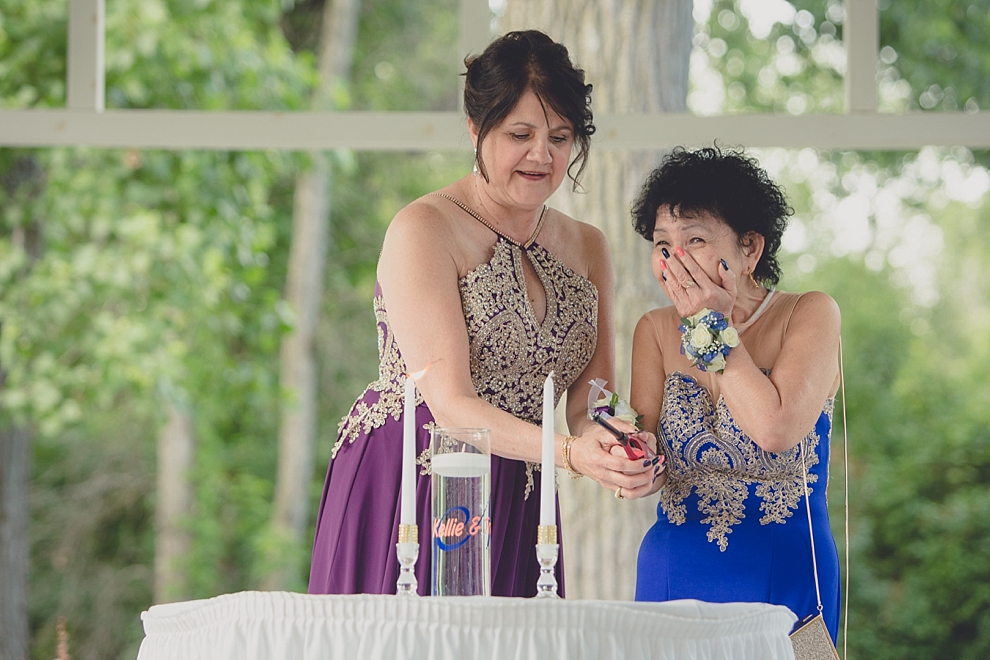 moms light candle during garden wedding ceremony at Samuel's Grande Manor near Buffalo, NY