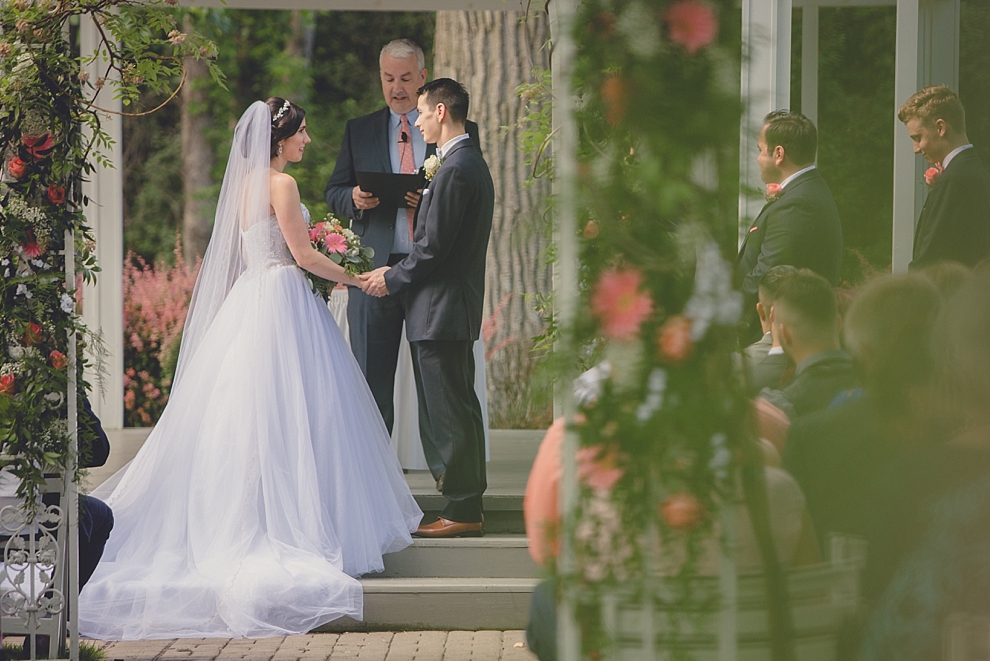bride and groom exchange vows during garden wedding ceremony at Samuel's Grande Manor near Buffalo, NY