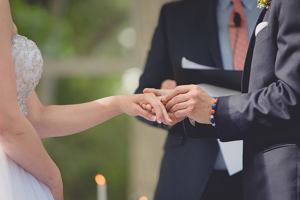 bride and groom exchange rings during garden wedding ceremony at Samuel's Grande Manor near Buffalo, NY