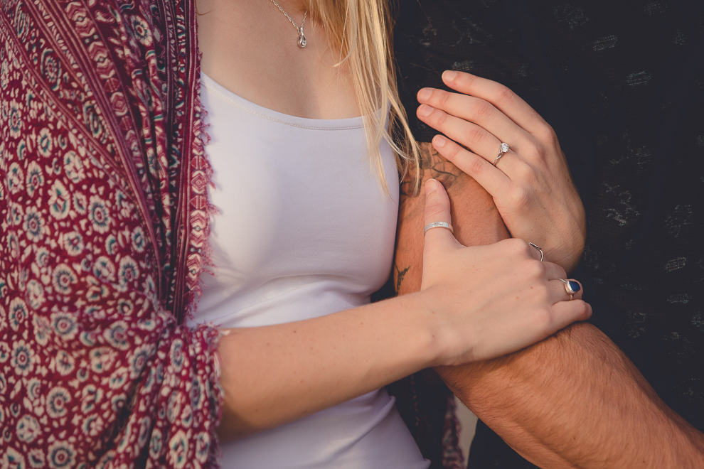 bride's hands wrapped around grooms arm on Gallagher Beach at Buffalo Harbor State Park in Buffalo, NY