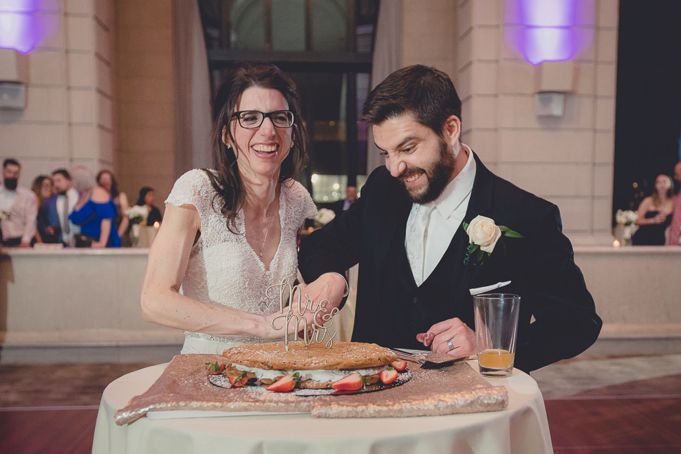 bride and groom cut giant ice cream cookie cake or "chipwhich" at ballroom wedding reception venue, the Admiral Room, in Buffalo, NY