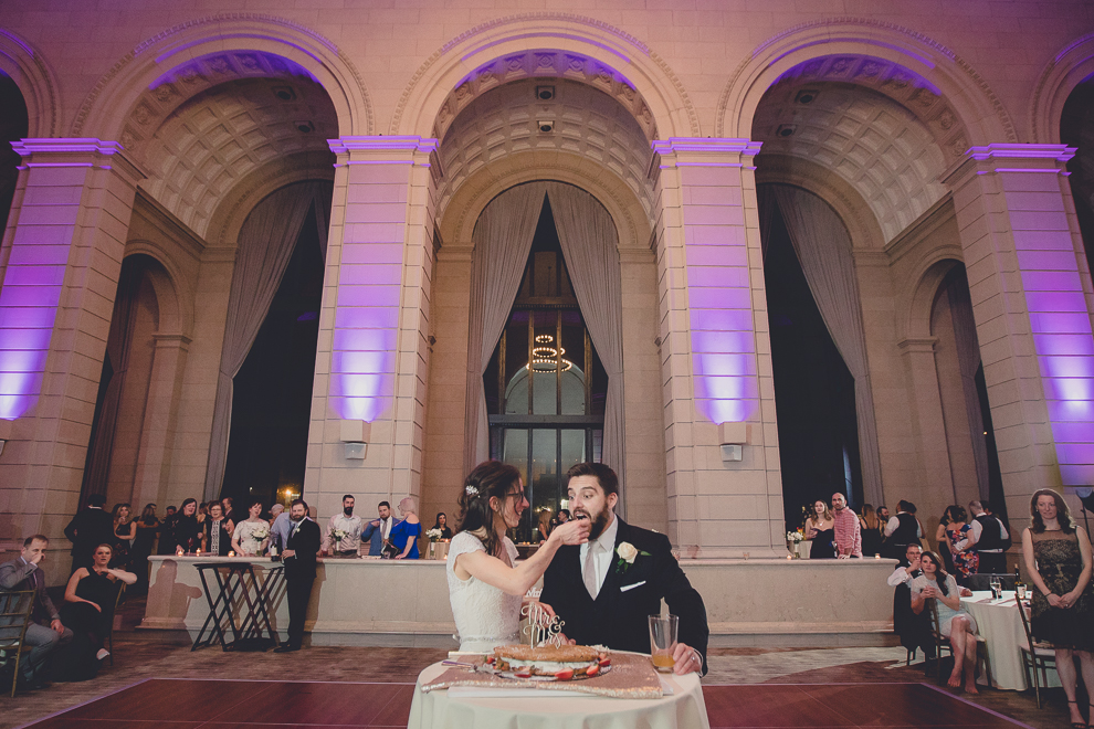 bride and groom eat giant ice cream cookie cake or "chipwhich" at ballroom wedding reception venue, the Admiral Room, in Buffalo, NY